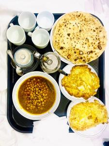 Airport Hotel Bed & Rest في كراتشي: صينية طعام مع حساء وصحن طعام