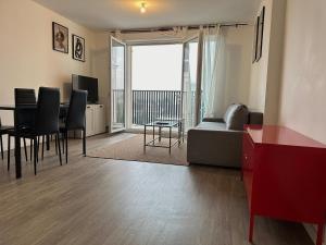 uma sala de estar com um sofá e uma mesa com cadeiras em T3 65 m2 avec parking 15 mns Paris by immo kit bnb em Gagny