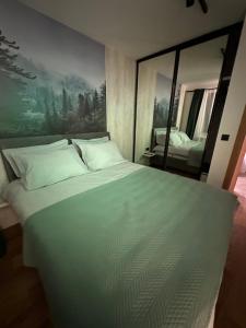 a large white bed in a room with a mirror at Apartman 15 in Jahorina