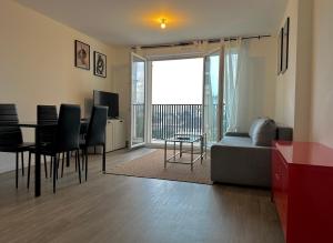 sala de estar con sofá y mesa con sillas en T3 65 m2 avec parking 15 mns Paris by immo kit bnb, en Gagny