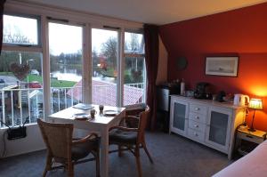 a room with a table and chairs and a balcony at B&B Ferdivedaasje in Dokkum