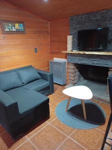 sala de estar con sofá y chimenea en Casa para 4 personas en San Carlos de Bariloche