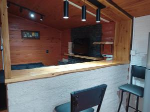 a bar in a room with two chairs and a fireplace at Casa para 4 personas in San Carlos de Bariloche