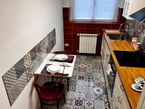 a small kitchen with a table with plates on it at Charm & History in Trieste in Trieste