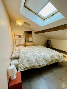 a bedroom with a bed and a skylight at Duplex + parking gratuit facile in Sainte-Suzanne