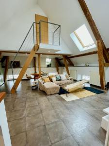 a large living room with a vaulted ceiling with a staircase at Duplex + parking gratuit facile in Sainte-Suzanne