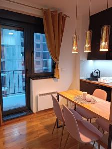 een keuken en eetkamer met een houten tafel en stoelen bij Apartman Lux Relax nalazi se u Titovoj vili in Palisat