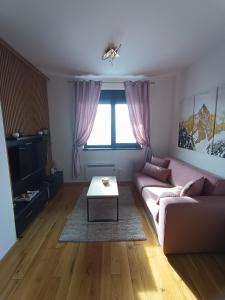 een woonkamer met een bank en een tafel bij Apartman Lux Relax nalazi se u Titovoj vili in Palisat