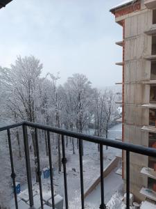 een balkon met met met sneeuw bedekte bomen en een gebouw bij Apartman Lux Relax nalazi se u Titovoj vili in Palisat