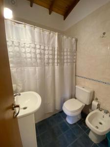 een badkamer met een wit toilet en een wastafel bij LAS DACHAS 2 Villa Gesell in Villa Gesell