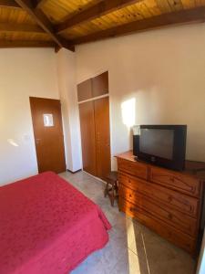 een slaapkamer met een bed en een flatscreen-tv bij LAS DACHAS 2 Villa Gesell in Villa Gesell +4 foto's