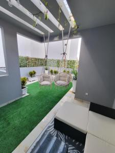 Una sala de estar con césped verde y un columpio. en Résidence Jordan, en Dakar