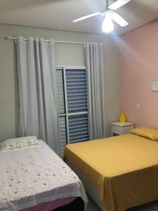 um quarto com 2 camas e uma ventoinha de tecto em Sobrado c/ PISCINA na Barra do Una (Litoral Norte) em São Sebastião