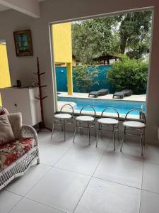 um quarto com uma mesa e cadeiras e uma piscina em Sobrado c/ PISCINA na Barra do Una (Litoral Norte) em São Sebastião