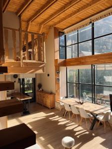 a dining room with tables and chairs and windows at Ca de Palomera Vall d’Aran in Les