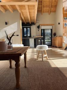 a living room with a table and a stool at Ca de Palomera Vall d’Aran in Les