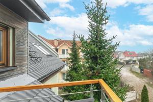 Un árbol de Navidad en el balcón de una casa en Apartament Bursztynowy en Rewal