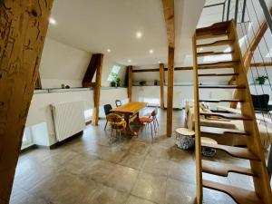 a room with a staircase and a table and chairs at Duplex + parking gratuit facile in Sainte-Suzanne