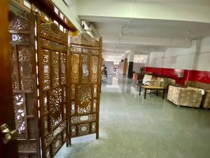 Habitación con puertas de madera, mesa y sillas. en Hotel Sova's Inn en Birātnagar