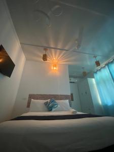 um quarto com uma cama com uma luz na parede em Saima Lodge em Himandhoo 