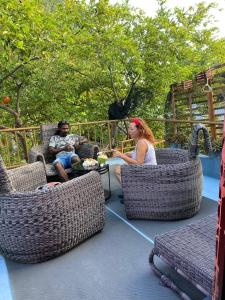 a man and woman sitting in wicker chairs on a patio at Saima Lodge in Himandhoo 