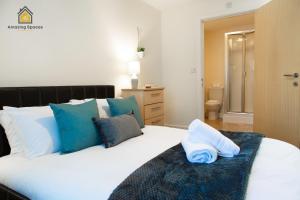 ウォリントンにあるSpacious 2Bedroom 2Bathroom Flat in Warrington by Amazing Spaces Relocations Ltd.のベッドルーム(青い枕の大きな白いベッド付)