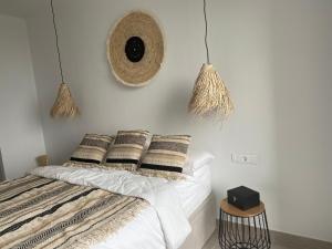 - une chambre avec un lit doté de draps et d'oreillers blancs dans l'établissement La casa del león dormido, à Polop