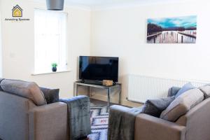 a living room with two couches and a tv at Spacious 2Bedroom 2Bathroom Flat in Warrington by Amazing Spaces Relocations Ltd. in Warrington