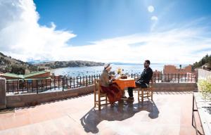 due persone sedute a un tavolo con vista sull'acqua di Guest House Sky Lake a Copacabana