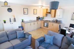 sala de estar con 2 sofás y cocina en Spacious 2Bedroom 2Bathroom Flat in Warrington by Amazing Spaces Relocations Ltd., en Warrington