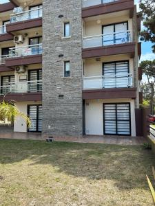 an apartment building with a yard in front of it at Complejo Médanos in San Bernardo