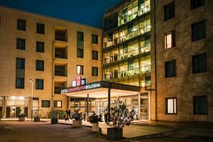 un edificio con un hotel con un cartel delante en Hotel Cosmopolitan Bologna, en Bolonia