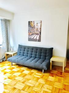 a blue couch in a living room with a wooden floor at Stylish Montreal Apartment: Comfortable Stay in the Golden Square Mile in Montreal