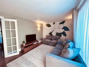 a living room with a blue couch and a television at Stunning 3BR House w/ Parking in Stevenage