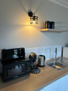 encimera de cocina con microondas y fregadero en Studio +++ très agréable en centre ville, en Doué-la-Fontaine