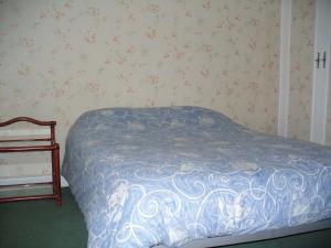 a bedroom with a bed with a blue comforter at Maison d'Hôtes Villa Brindille in Bois-le-Roi