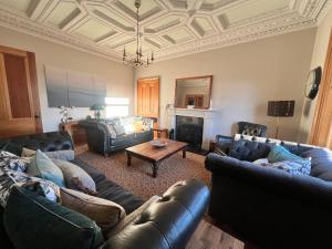sala de estar con muebles de cuero y techo artesonado en Morven Guest House Carnoustie, en Carnoustie