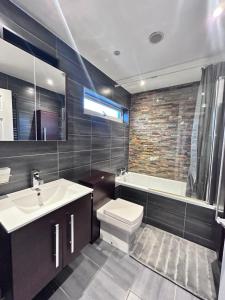 łazienka z umywalką, toaletą i wanną w obiekcie Stunning 3BR House w/ Parking w mieście Stevenage