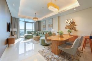 uma sala de estar com um sofá, uma mesa e cadeiras em Luxurious one bedroom Apartment em Dubai
