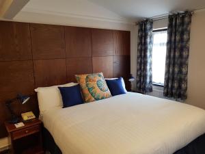 um quarto com uma grande cama branca com almofadas azuis em Heights Hotel em Portland