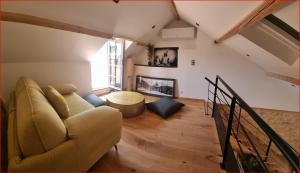 sala de estar con sofá y chimenea en Appartement avec Terrasse & Parking Sarlat centre, en Sarlat-la-Canéda