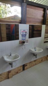 uma casa de banho com dois lavatórios e placas na parede em Ecopradera em San José del Guaviare