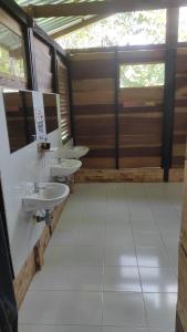 a bathroom with two sinks and two windows at Ecopradera Lodge in San José del Guaviare