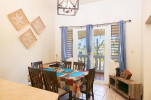 comedor con mesa, sillas y ventana en Golden Dream Villas 306/A, en Isabela