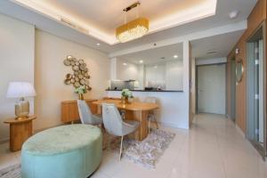 a living room with a table and chairs and a kitchen at Luxurious one bedroom Apartment in Dubai