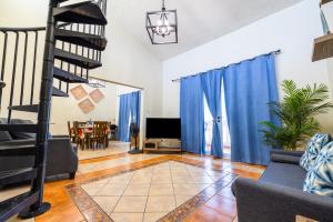 sala de estar con cortinas azules y escalera en Golden Dream Villas 306/A en Isabela