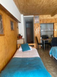 a bedroom with a bed and a dining room at Hospedaje Cabaña y Restaurante Don Niba in Villa Cerro Castillo