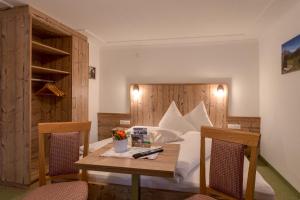 a bedroom with a bed with a table and chairs at Albert'n Haus in Längenfeld