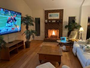 a living room with a large television and a fireplace at The Retreat at Davis Mill in Germantown