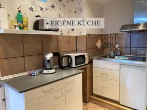 ヴレーメンにあるKrabbe Apartment 6, für bis zu 2 Personen, bis zu 2 Hunden kostenfrei willkommen, kostenfreier Parkplatz, einfacher Check-in und Schlüsselboxの小さなキッチン(電子レンジ、カウンター付)